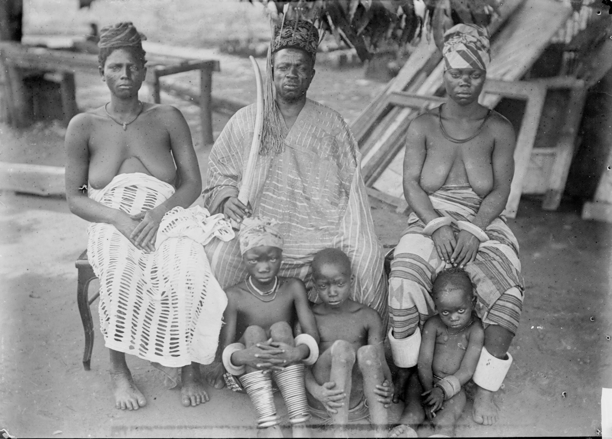 A photograph depicting a family group with an adult male, two adult females, and three children along the Niger River.