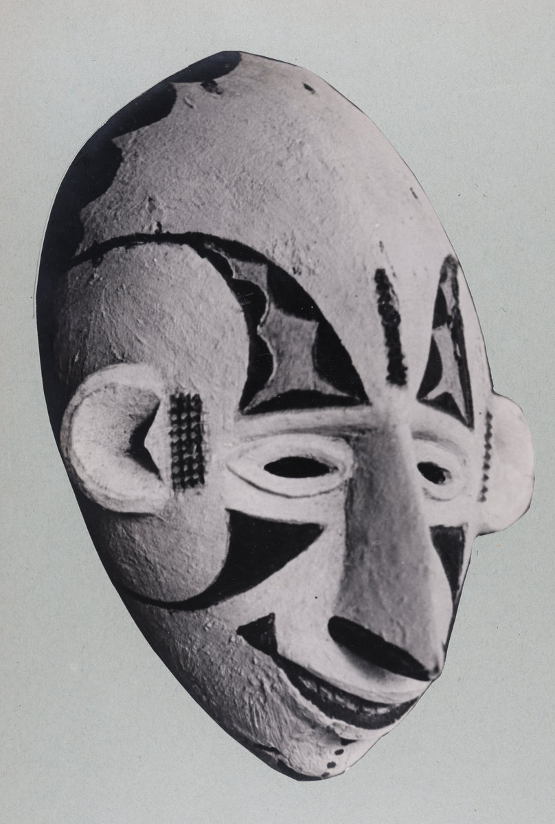 A white Mau ghost face mask with black geometric markings and an elongated nose.