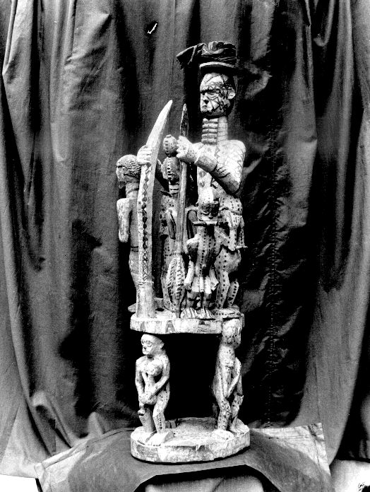 Multi-tiered carved wooden shrine object with anthropomorphic figures.